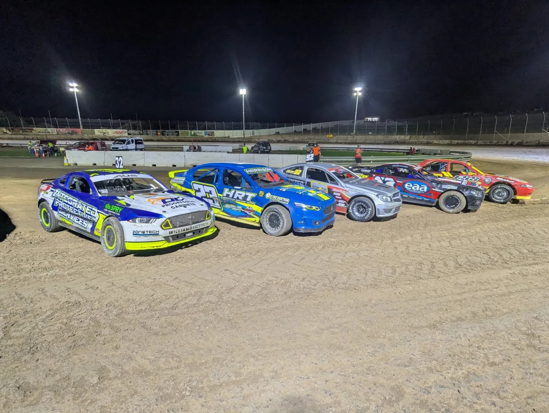 Full grid of Modified Sedans under the lights at Murray Bridge Speedway with #32 leading from the front