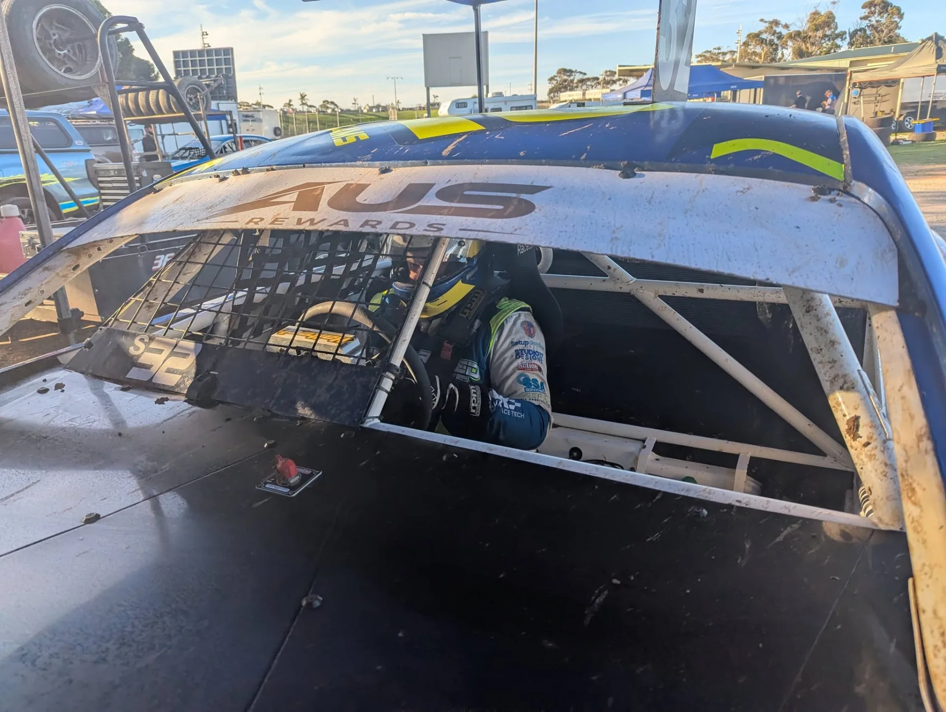 Brett Williams helmeted in the cockpit, seen through the window net