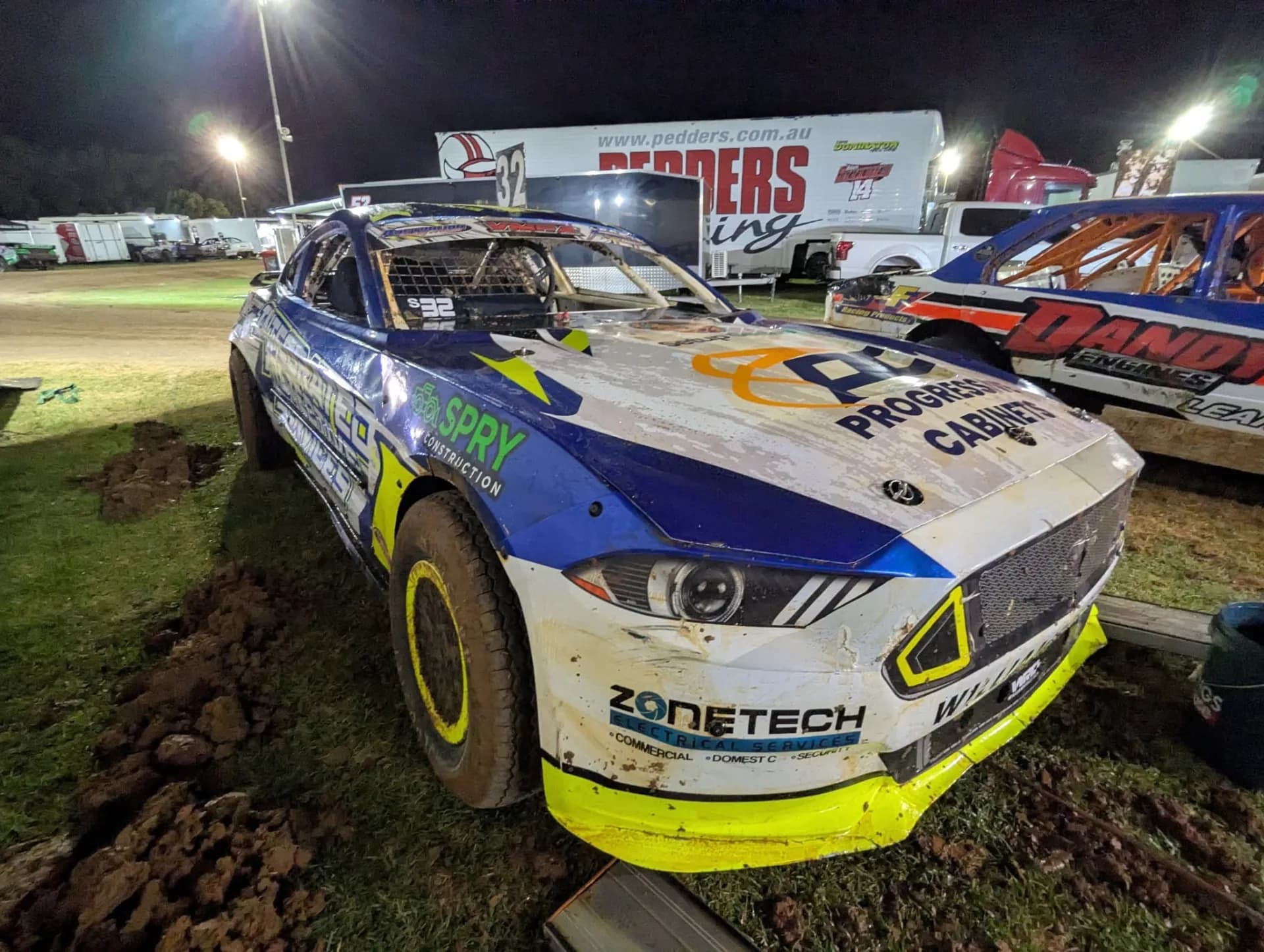 The battle-worn #32 WRT Mustang in the night pits — grassroots racing at its most authentic